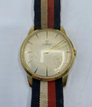 A Tissot vintage automatic wristwatch. 35mm yellow metal case, champagne dial with gold baton