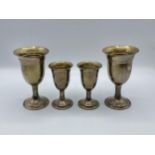 A pair of sterling silver goblets together with a smaller pair of matching silver goblets by W I