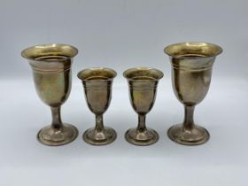 A pair of sterling silver goblets together with a smaller pair of matching silver goblets by W I