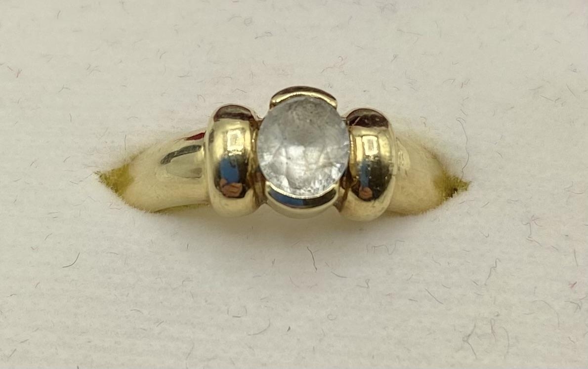 A 14ct gold and white sapphire single stone ring, central oval free cut bezel set sapphire. 4.46g. - Image 2 of 4