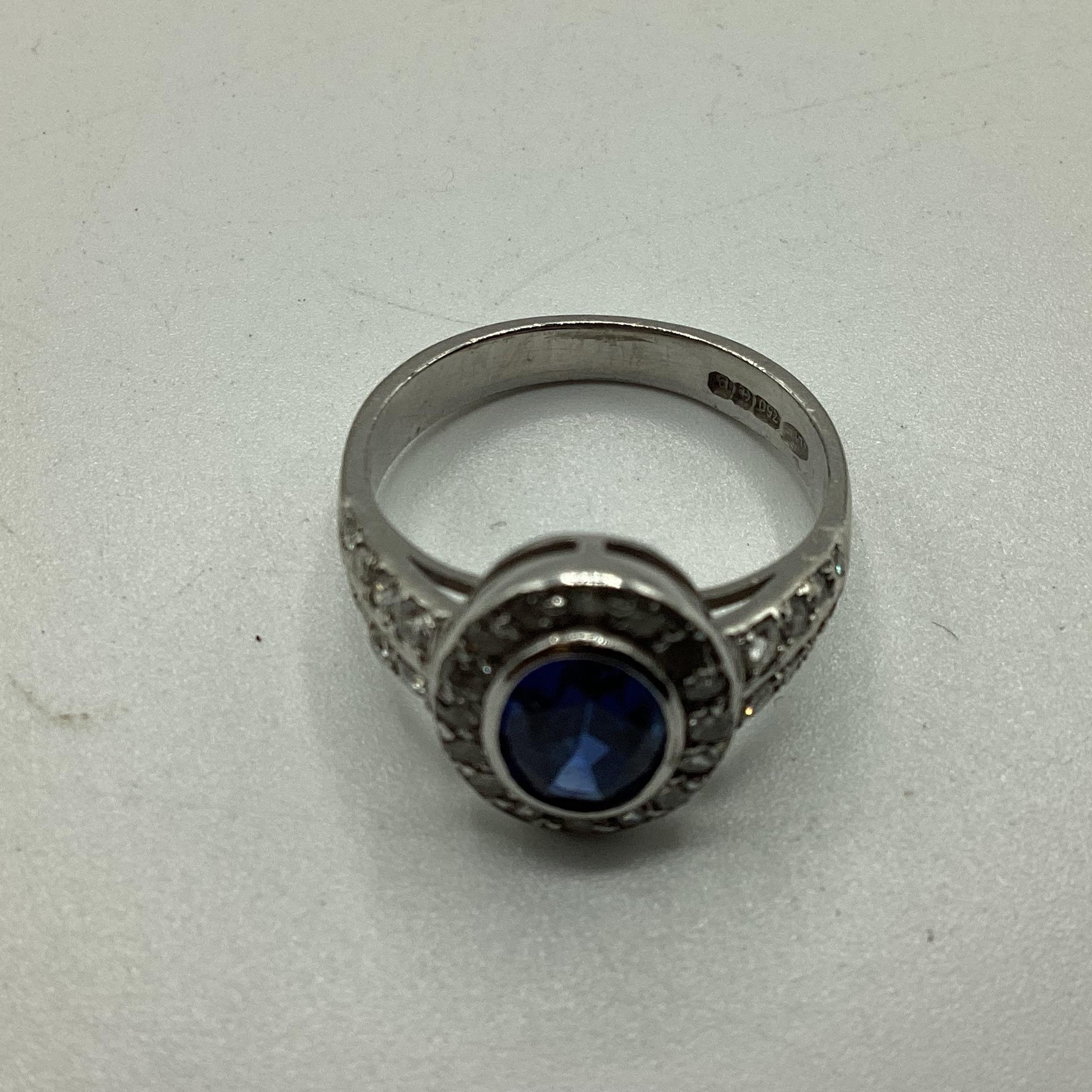 A 18ct white gold sapphire and diamond ring, central oval free cut sapphire in a rub over setting - Image 2 of 4