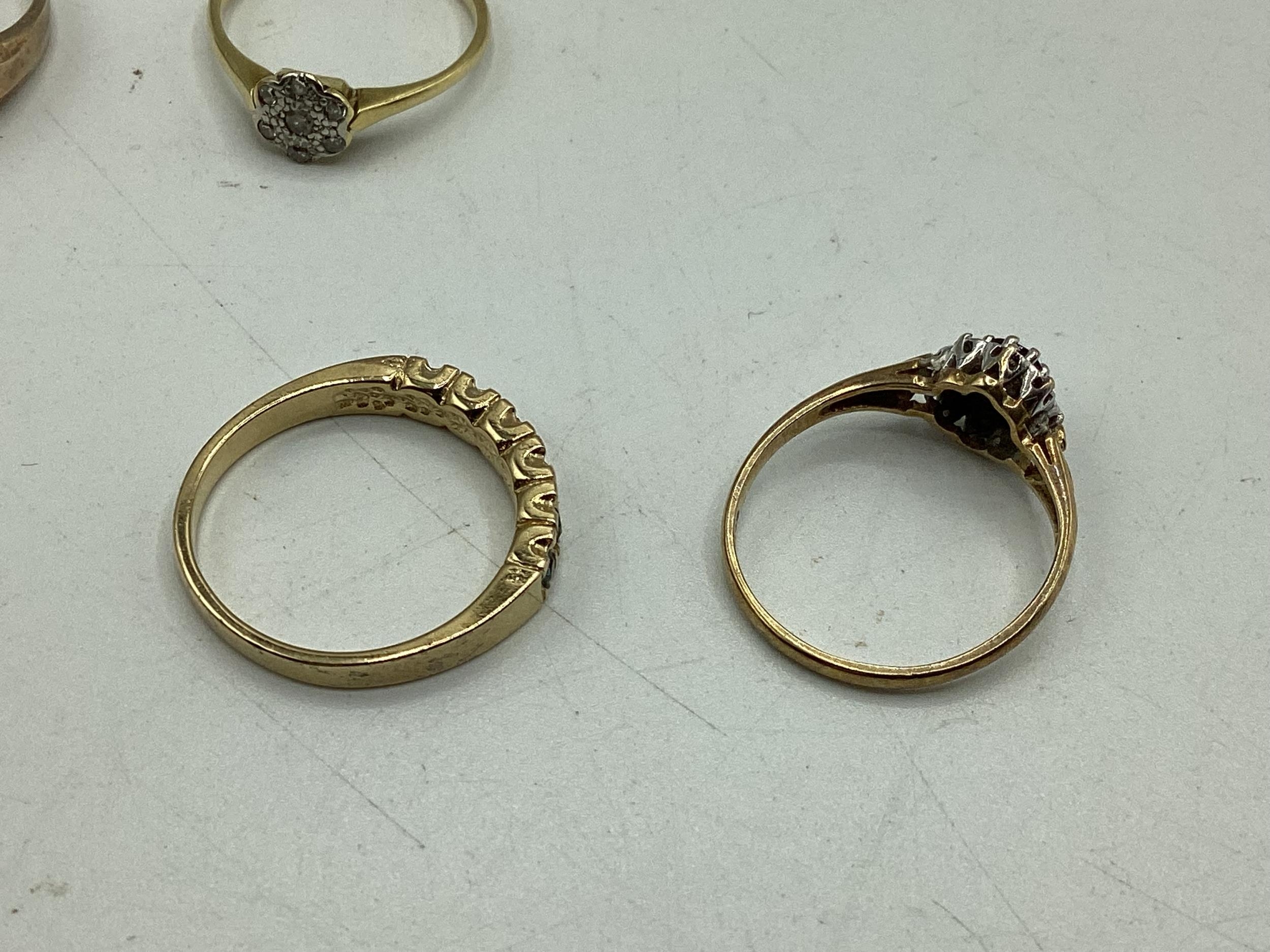 A collection of 9ct / 18ct gold and unmarked yellow metal rings to include a diamond set flower - Image 4 of 4