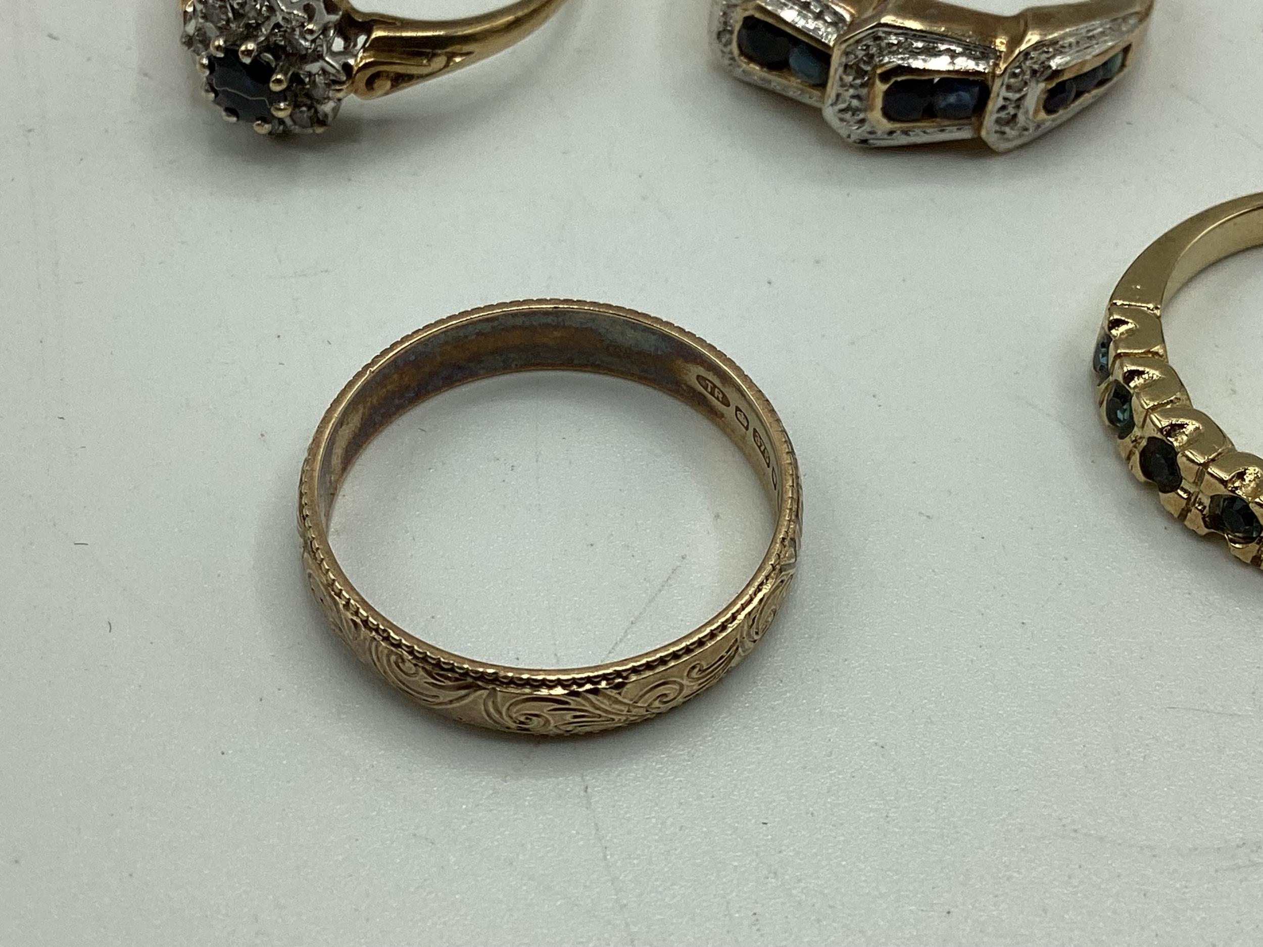 A collection of 9ct / 18ct gold and unmarked yellow metal rings to include a diamond set flower - Image 3 of 4