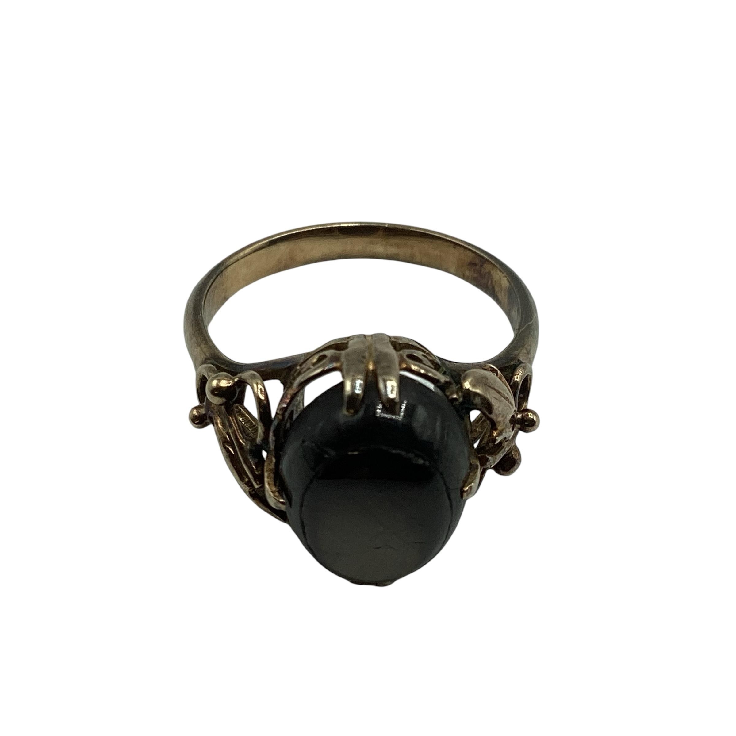 An 18ct gold black star sapphire set ladies dress ring, with scrolling floral shoulders, 4.06 g,