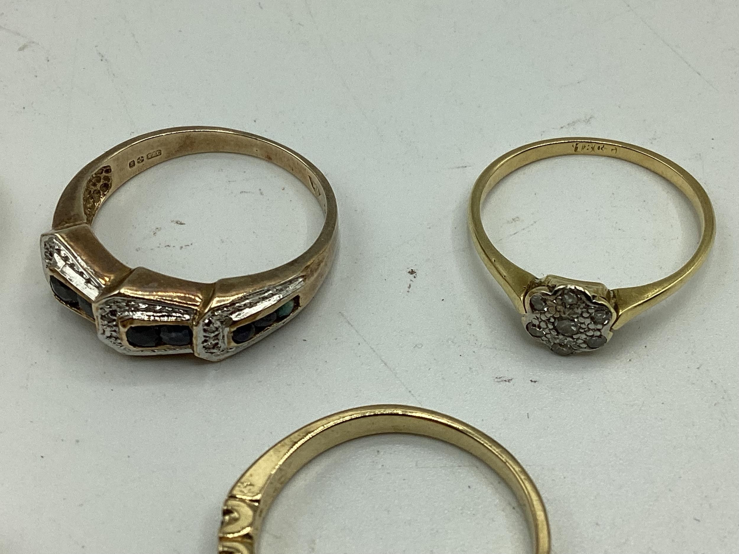 A collection of 9ct / 18ct gold and unmarked yellow metal rings to include a diamond set flower - Image 2 of 4