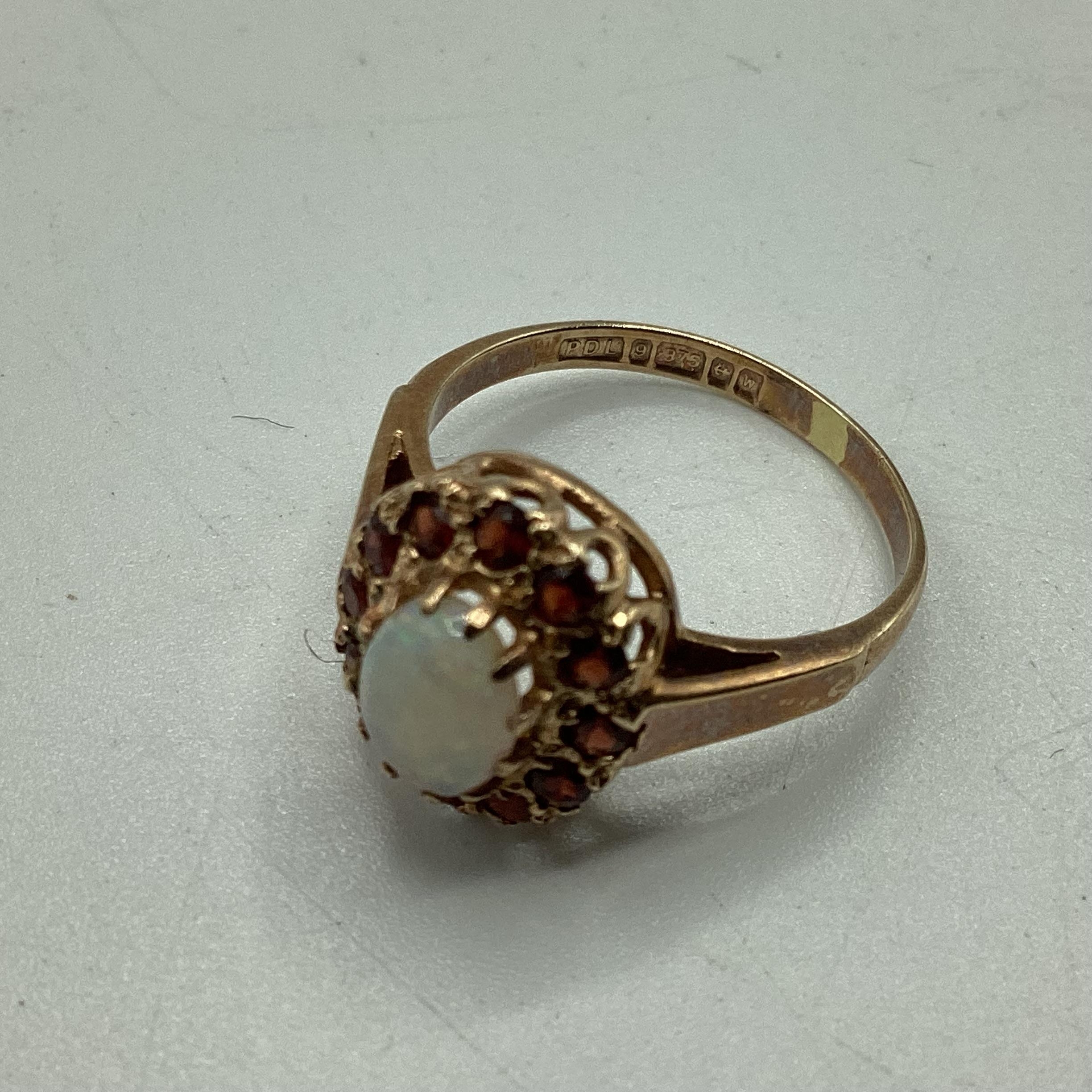 9 ct gold opal and garnet ring central oval opal with a surround of single cut red garnets size K, - Image 2 of 5