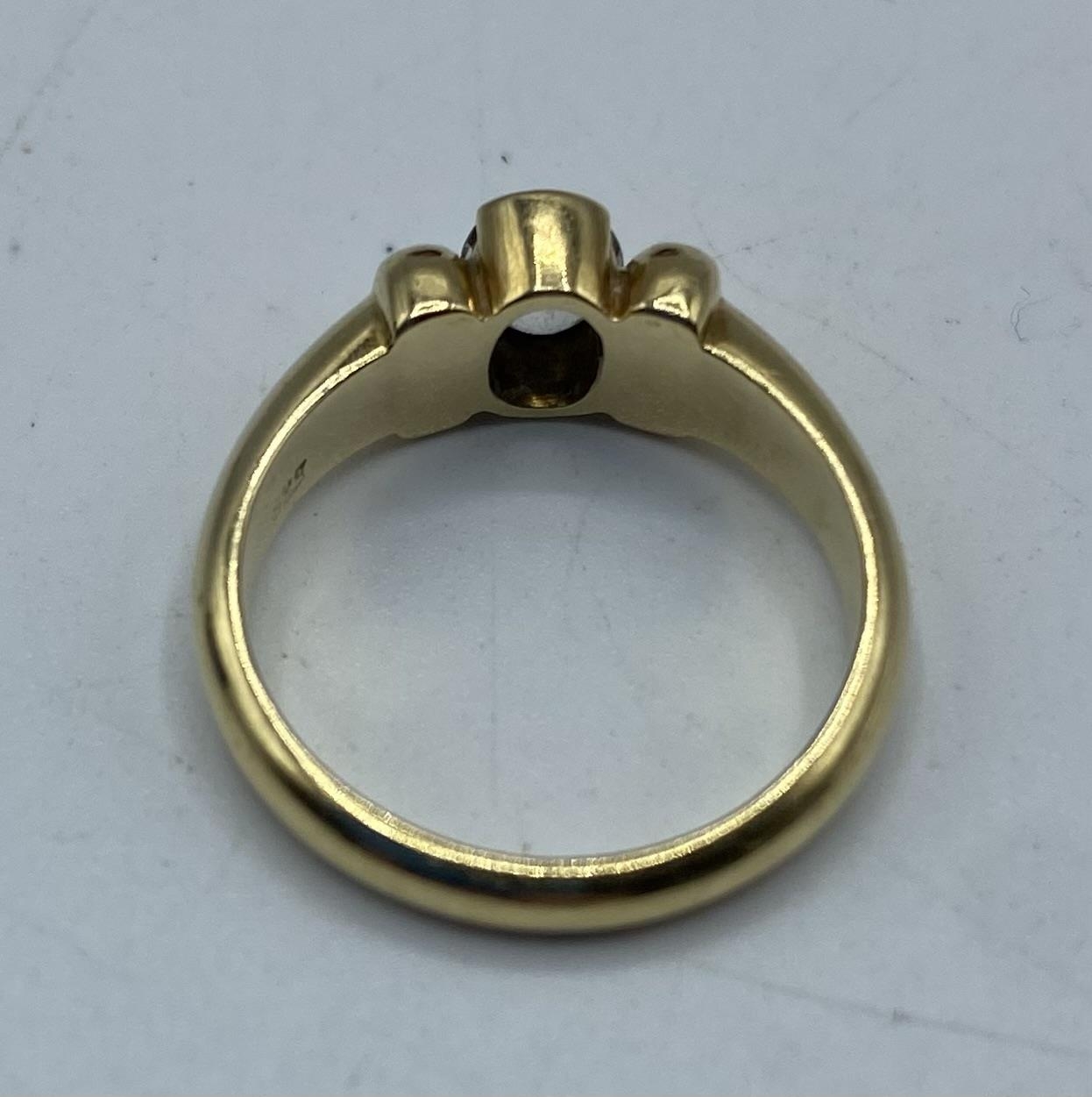 A 14ct gold and white sapphire single stone ring, central oval free cut bezel set sapphire. 4.46g. - Image 3 of 4