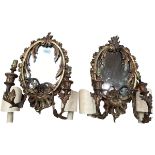 A pair of oval sconces, with mirrored back and ornate floral carved gesso surround, 39cm High