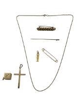 A collection of 9ct gold items , crucifix, ingot pendant and chain, pin brooch, together with a 10ct