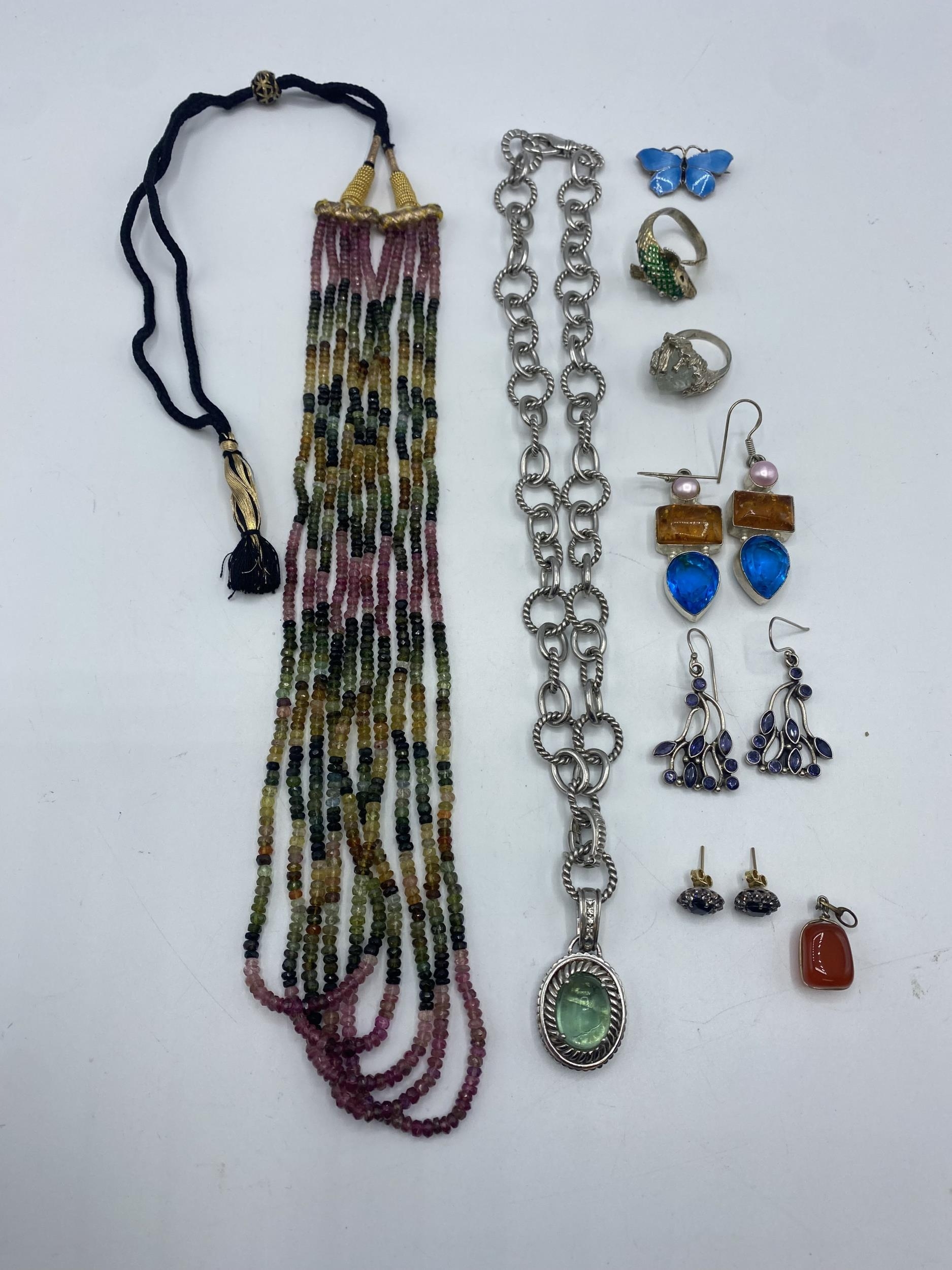 A collection of sterling silver . white metal costume and bead jewellery to include a enamel