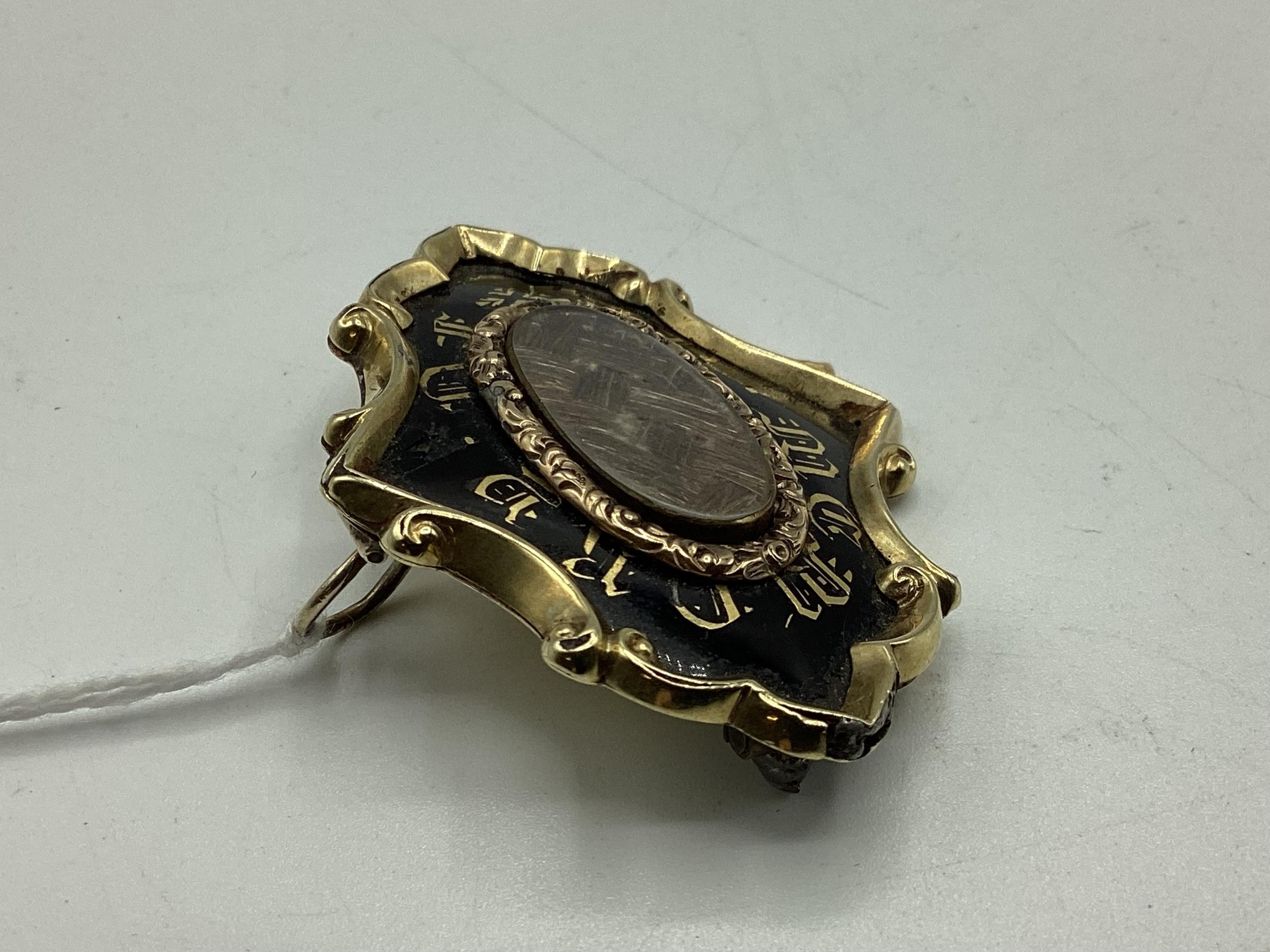 An unmarked yellow metal and black enamel mourning Brooch with woven hair panel to centre, with gold - Image 4 of 4