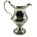 A sterling silver cream jug with repoussé decoration on a beaded circular foot 103 g