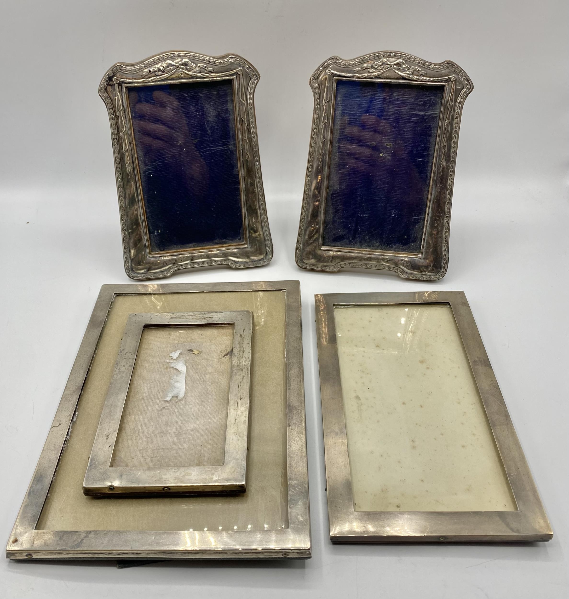 Pair of sterling silver easel backed picture frames together with a set of three sterling silver