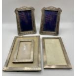 Pair of sterling silver easel backed picture frames together with a set of three sterling silver
