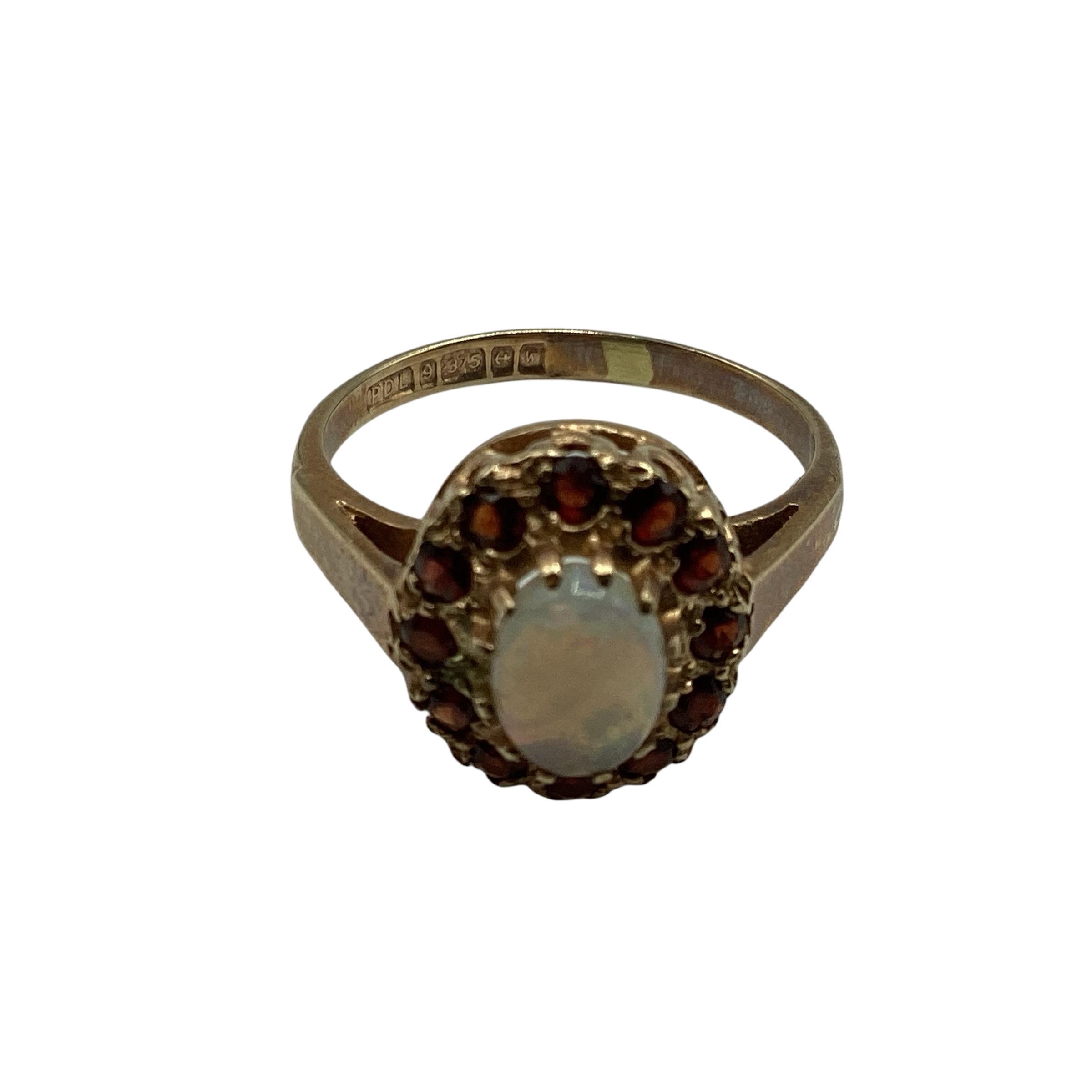 9 ct gold opal and garnet ring central oval opal with a surround of single cut red garnets size K,
