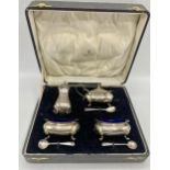A boxed sterling silver condiment set to include salts, mustard, pepperette and spoons, total silver