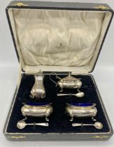 A boxed sterling silver condiment set to include salts, mustard, pepperette and spoons, total silver