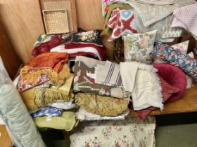A very sizeable quantity of curtains, material, cushion covers, cushions, bedspread, rugs, baskets