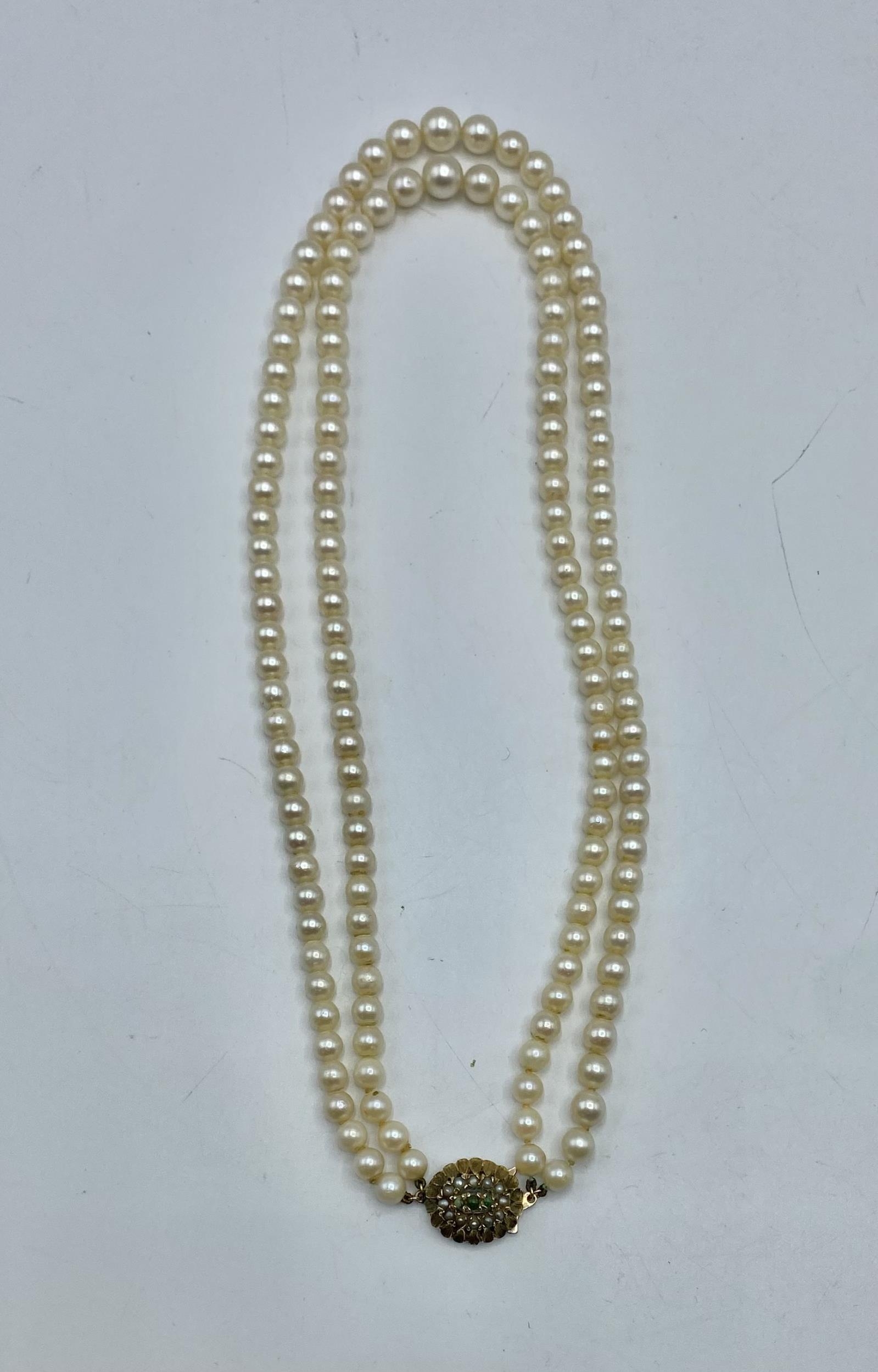 A double strand of graduated cultured pearls on a pearl set 9ct gold clasp. 48cm.