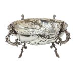A Georgian sterling silver bowl with cast supports and dog head finials and repousse swirling