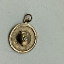 A 9ct gold and diamond set circular pendant. 2.4g