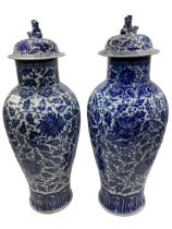 A pair of C20th blue and white baluster vases with covers and fo dog finials, some wear and