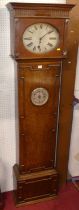 An early 20th century geometric moulded oak longcase clock, having a silvered oval dial, the door