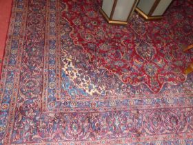 A Persian woollen red and blue ground Tabriz rug, the floral central ground within various