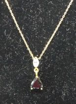 A sapphire and diamond pendant arranged as a 3 claw set trillion cut sapphire below a marquise cut
