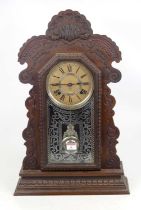 An early 20th century American gingerbread type clock, the paper dial showing Roman numerals and