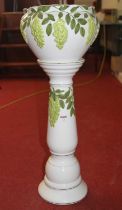 A pottery jardiniere and stand relief decorated with vines, height 79cm
