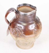 A 19th century salt glazed stoneware harvest pattern jug, having a silver plated rim, height 24cm (