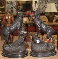 A large pair of bronzed models of stags, each signed J Moigriix and upon black polished hardstone