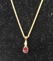 A modern 9ct gold ruby and diamond set pendant on fine link neck chain, gross weight 2.9g Chain