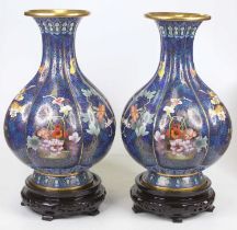 A pair of Chinese cloisonne enamel vases, each of ribbed lower baluster form, on varnished wooden