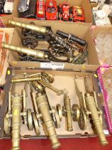 Two boxes of ornamental cannons, to include brass and cast iron examples