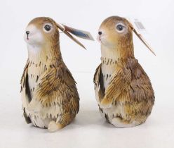 A pair of painted metal seated rabbits, 21cm