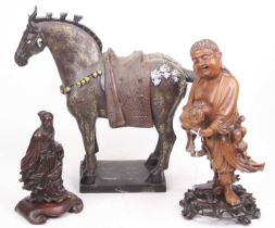 A Chinese carved hardwood figure of a man holding a lizard, standing on naturalistic base, height
