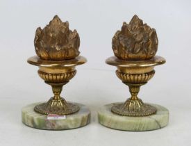 A pair of polished brass garnitures, each in the form of a flaming urn, mounted to a circular