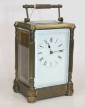 A brass carriage clock, the enamel dial showing Roman numerals, having visible platform