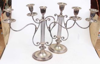 A pair of Edwardian silver plated three branch table candelabra having an oval sconce on knopped