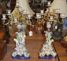 A pair of porcelain and gilt metal table candlesticks in the Rococo taste, h.61cm