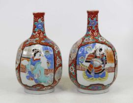 A pair of Japanese porcelain vases, each having a slender neck above a bulbous body, enamel