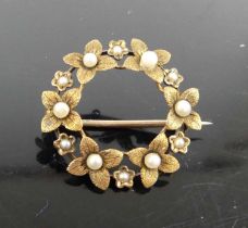 A yellow metal and seed pearl set openwork brooch, 2.6g, unmarked but tests as approx 9ct gold,