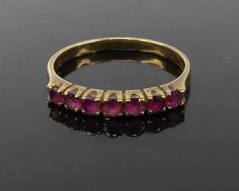 A modern 9ct gold and ruby set half eternity ring, 1.6g, size M