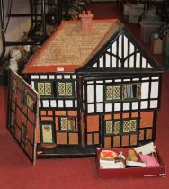 A painted wooden dolls house together with a small collection of dolls house furniture