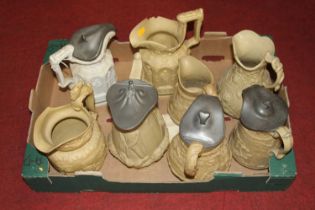 A collection of eight Victorian relief moulded pottery jugs One missing lid.One with damage to its