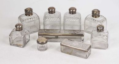A collection of nine silver lidded glass dressing table jars, together with a silver condiment spoon