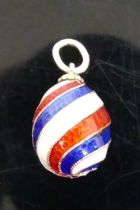 A Russian yellow metal and enamel egg shaped pendant in red, white and blue spiral bands, maker HW