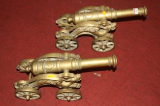 A pair of cast brass models of cannons on carriages, length 43cm